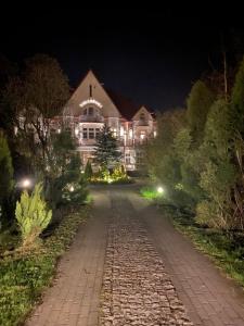 duży dom w nocy z brukowaną drogą w obiekcie Willa Granit w Krościenku