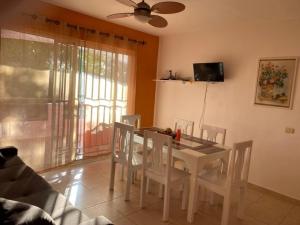a dining room with a white table and chairs at Sunny Apartment in Bayahibe