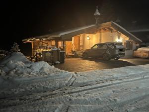 ザールバッハ・ヒンターグレムにあるChalet Tannenbaumの雪に覆われた家の前に停められた車