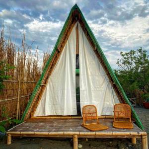 a triangular tent with two chairs on a wooden table at La Luna Elyu 