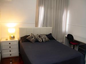 a bedroom with a bed and a desk with a lamp at Apartamento Gutierrez 1 in Belo Horizonte