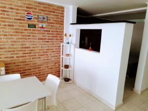 a room with a brick wall and a white table and chairs at Alquiler por día General Viilegas in General Villegas