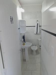 a white bathroom with a sink and a toilet at Alquiler por día General Viilegas in General Villegas