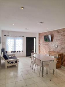 a dining room with a table and chairs and a brick wall at Alquiler por día General Viilegas in General Villegas