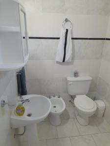 ein weißes Badezimmer mit Toilette und Waschbecken in der Unterkunft Alquiler por día General Villegas in General Villegas + 12 Fotos