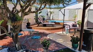 un patio con un árbol y una piscina en Le petit coin de Provence en Beaucaire