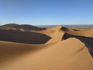 a group of sand dunes in the desert at Bivouac Le charme d'Aladdin in El Gouera
