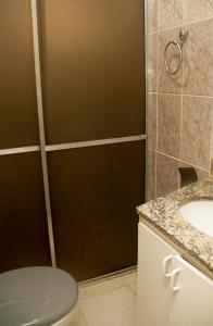 y baño con ducha, aseo y lavamanos. en Apartamento Gutierrez 1, en Belo Horizonte