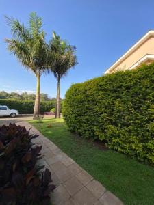 two palm trees and a sidewalk next to a building at Daria Apartment -Burka -3 minutes from Arusha Airport in Arusha