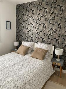 a bedroom with a bed with a floral accent wall at Appartement cosy près de la gare avec parking in Saint-Pierre-des-Corps