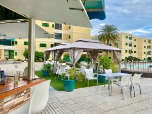 taras ze stołami, krzesłami i parasolem w obiekcie Apartamento Las Olas • Playa del Inglés w mieście Playa del Ingles