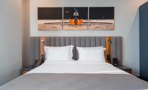 a bedroom with a bed with three paintings on the wall at Onyx City Center in Tbilisi City