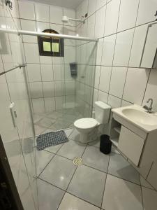 W łazience znajduje się prysznic, toaleta i umywalka. w obiekcie Boca da Lagoa - Onde o Sol, o Mar e a Montanha se Encontram w mieście Boiçucanga