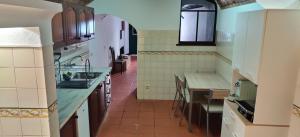 una cocina con fregadero y mesa. en Casa da Cal Branca en Évora