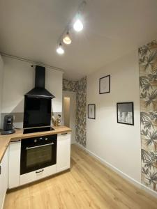 a kitchen with a stove top oven in a room at Appartement cosy près de la gare avec parking in Saint-Pierre-des-Corps