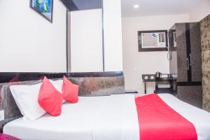 a bedroom with a large white bed with red pillows at OYO Hotel Executive Inn in Agartala