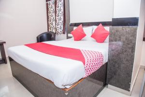 a bedroom with a bed with red pillows at OYO Hotel Executive Inn in Agartala