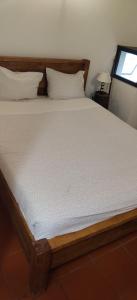 łóżko w sypialni z drewnianą ramą w obiekcie Casa da Cal Branca w mieście Évora
