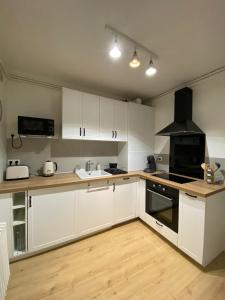 una cucina con armadi bianchi e piano cottura di Appartement cosy près de la gare avec parking a Saint-Pierre-des-Corps