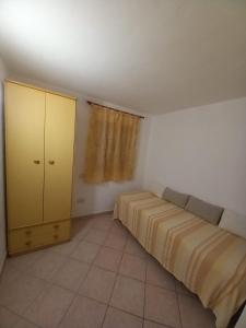 a bedroom with a bed and a yellow cabinet at Casa Roberto in Arzachena