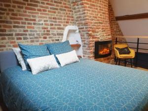 a bedroom with a bed and a brick wall at Calme/ Confortable / Esthétique / Centre-ville in Valenciennes