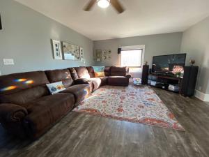 a living room with a brown leather couch and a television at Spacious 4BR 3BA Minutes to Starved Rock 