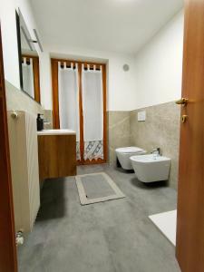 uma casa de banho com uma banheira, um lavatório e um WC. em Appartamento il Cervo em Fai della Paganella