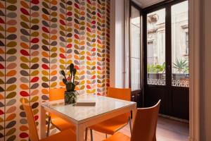 a dining room with a table and orange chairs at Chebedda B&B in Catania