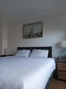 um quarto com uma cama branca e uma fotografia na parede em Alma nova vista al mar em Antofagasta