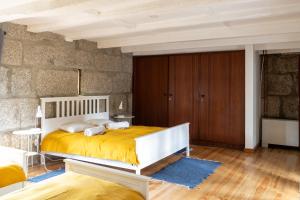 a bedroom with a bed and a stone wall at Casa da Guarda de Fora in Paredes +61 photos