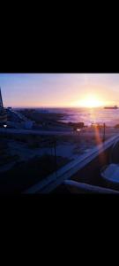 um ecrã de televisão com um pôr-do-sol ao fundo em Alma nova vista al mar em Antofagasta