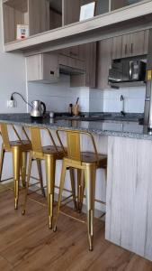 uma cozinha com cadeiras douradas num balcão de cozinha em Alma nova vista al mar em Antofagasta