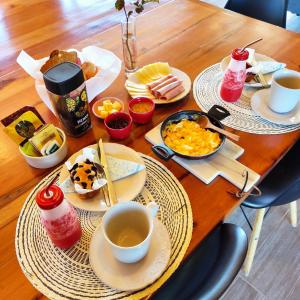a wooden table topped with plates of breakfast food at Casa Rayen Puerto Varas in Puerto Varas