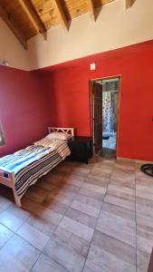 1 dormitorio con paredes rojas y 1 cama en una habitación en Casa Necha en Vaqueros