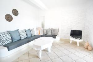 a living room with a couch and a tv at Sea Breeze Mykonos in Mykonos