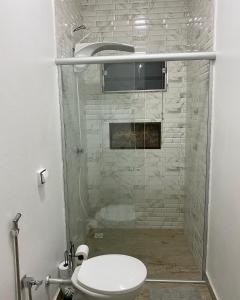 a bathroom with a shower with a toilet in it at Pousada Chalés Praia Vermelha in São João Batista do Glória