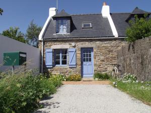 une petite maison en pierre avec une porte bleue dans l'établissement Maison Le Palais, 3 pièces, 3 personnes - FR-1-418-221, au Palais