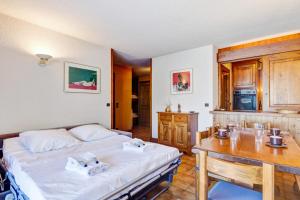 a bedroom with a bed and a wooden table at Appartement Breya - Welkeys in Megève