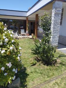 a yard with flowers in front of a house at HOSTAL LA MODERNA in Quintero