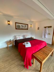 a bedroom with a large bed with a red blanket at CHALÉS SÓ COISAS BOAS in Ouro Preto