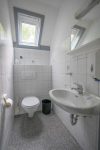 een witte badkamer met een toilet en een wastafel bij Ferienhaus am See im Bergland in Kirchheim