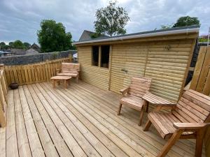 drewniany taras z 2 krzesłami i kabiną w obiekcie Sunshine Cottage w mieście Buxton