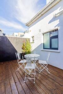 a patio with a table and chairs on a deck at Newly Refurbished Traditional Cottage Blackrock in Blackrock