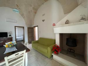 un soggiorno con divano verde e camino di L'Antico Camino a Pezze di Greco