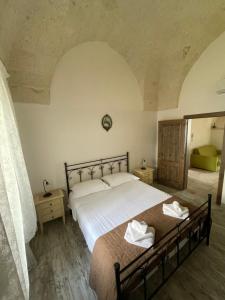 una camera da letto con un grande letto con lenzuola bianche di L'Antico Camino a Pezze di Greco