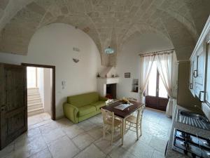 un soggiorno con divano verde e tavolo di L'Antico Camino a Pezze di Greco