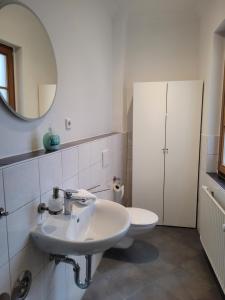 a bathroom with a sink and a toilet and a mirror at Stadthaus nahe Fußgängerzone in Hagen