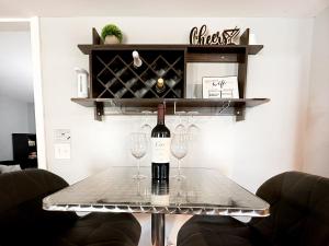 a table with a bottle of wine and two glasses at Cute 2-BRM Walkout apt with pool table and theater in Lexington