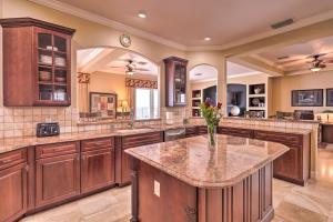 a large kitchen with a center island with a vase of flowers at Riverfront Titusville Home with Pool and Pickleball! in Titusville