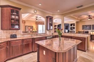 a large kitchen with a center island with a vase of flowers at Riverfront Titusville Resort Home with Infinity Pool in Titusville